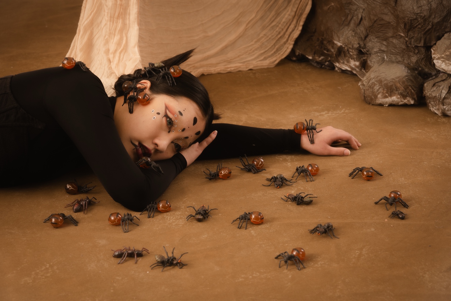 A model reclining among amber insect props in the set for Experimental Fashion Photography